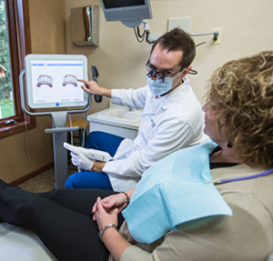 Dr. Hull explains the benefits of Invisalign clear braces to a Grand Rapids patient at his Comstock Park office.