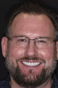 Full Face after photo of full mouth reconstruction patient Brad smiling wide to show off his new smile!