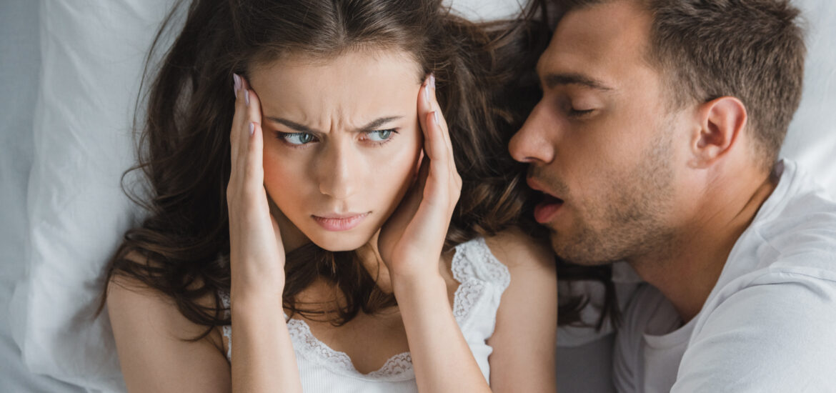 man snoring in his partners ear disrupting her sleep