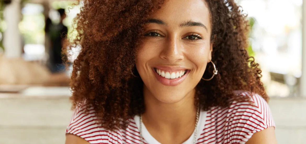 Headshot of beautiful dark skinned female, perfect white teeth