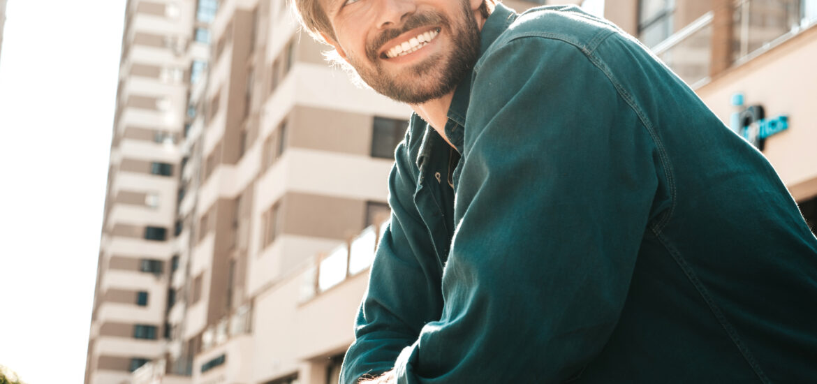 portrait of a young man leaning on balcony, perfect white teeth