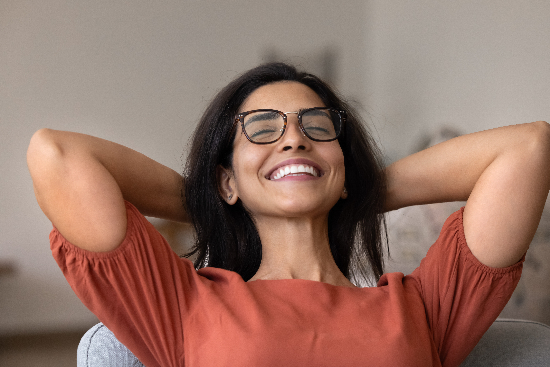 relaxed young woman smiling in a dental chair, hands behind her head